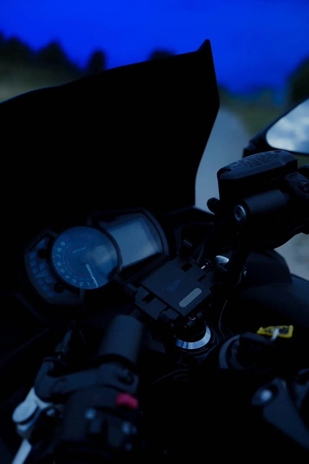 Le cockpit et le compteur de la moto dans la pénombre.